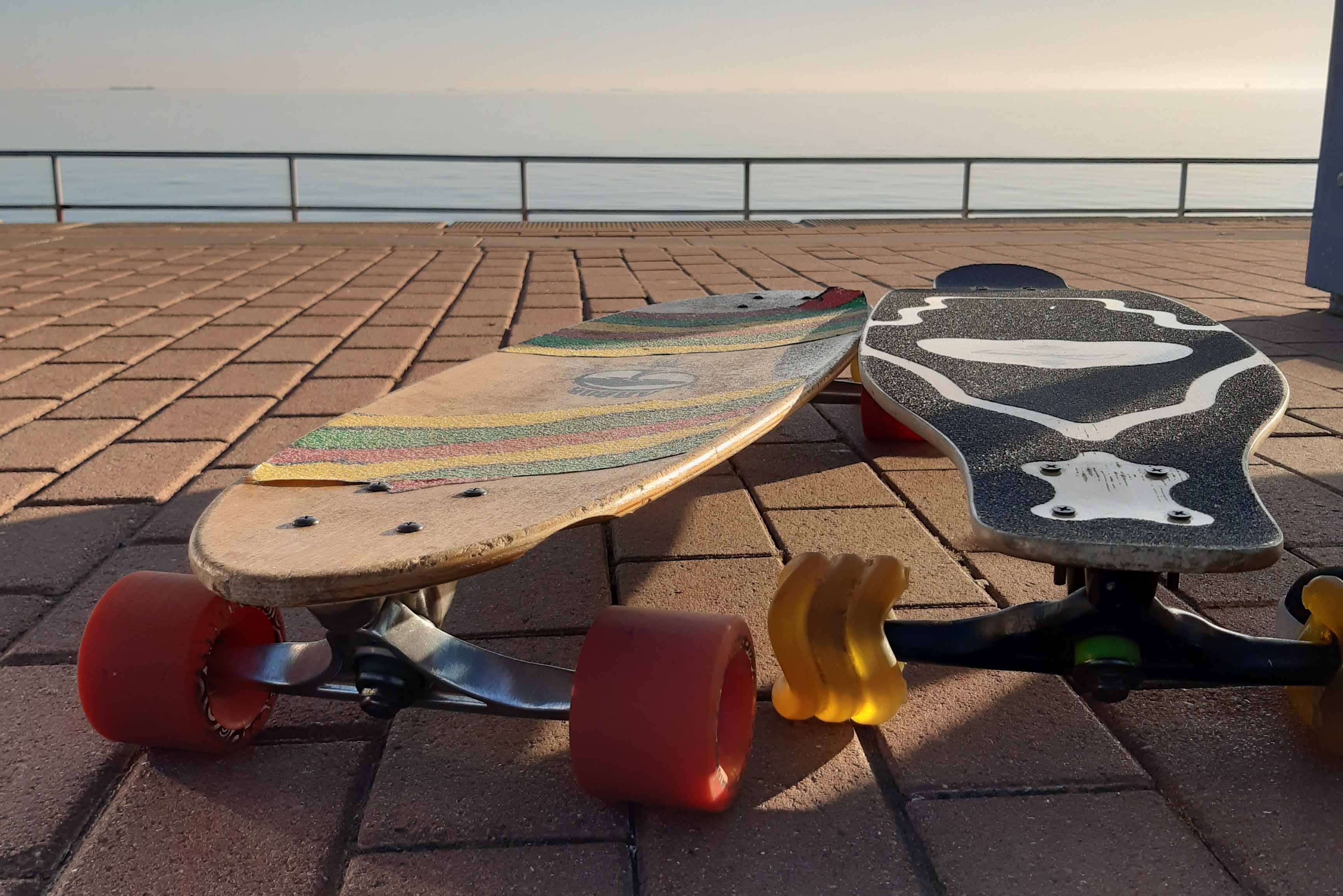 Two Longboards In The Sun Infront Of Water